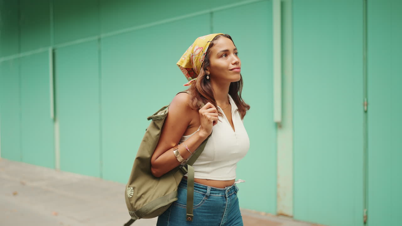 una mujer con una mochila caminando por la calle
