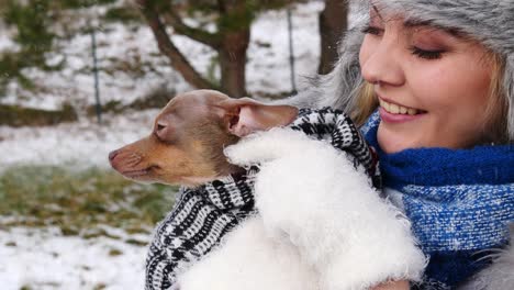 woman playing with her little dog outside winter