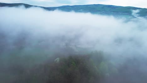ripresa aerea cinematografica nebbia densa sopraelevata che si trova nella valle di campagna