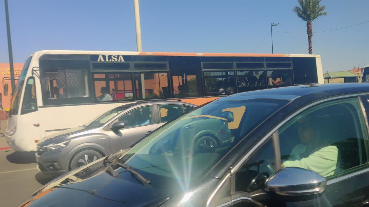 People walking near the Medina walls of Marrakesh under a bright sunny sky