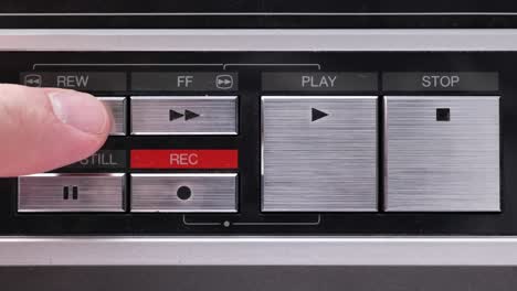 Extreme-close-up-of-buttons-on-an-old-antique-or-vintage-VCR-Pushing-Rewind