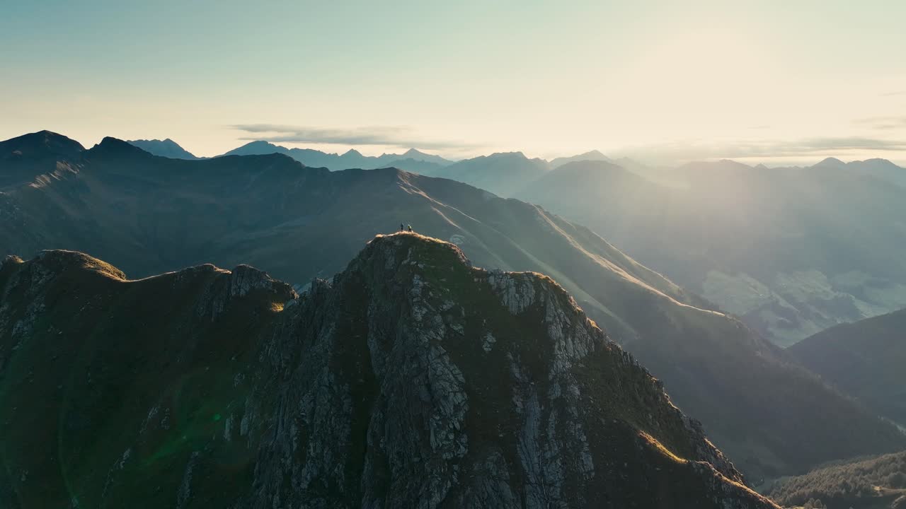 Two people hiking up a mountain in the Alps in between Austria and Italy.
