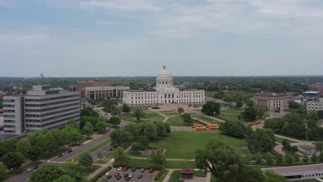 Toma-Aérea-Descendente-Súper-Amplia-Hacia-La-Bandera-De-Los-Estados-Unidos-Frente-Al-Edificio-Del-Capitolio-Del-Estado-De-Minnesota-En-Saint-Paul,-Minnesota