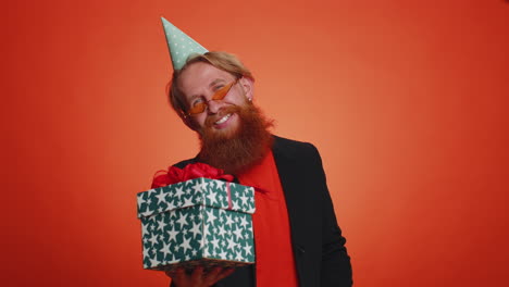 hombre sonriente presentando caja de regalos de cumpleaños extiende las manos, ofrece un regalo envuelto bonificación de carrera