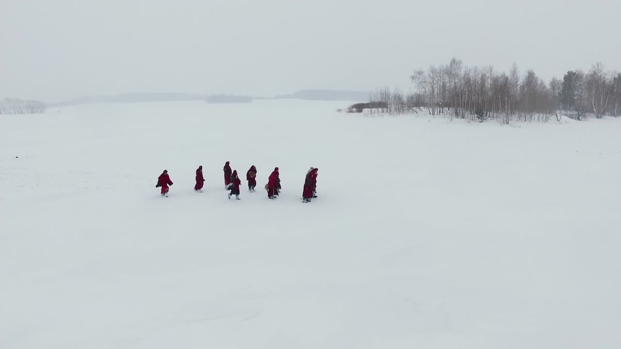 Monks Walking on Frozen Lake in Winter