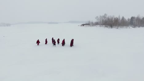 monks walking on frozen lake in winter