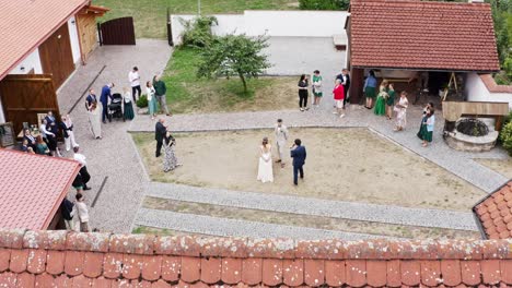 best man interviewing newlywed couple at homestead wedding, drone shot