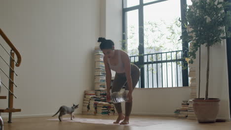 woman doing a home workout with a water bottle