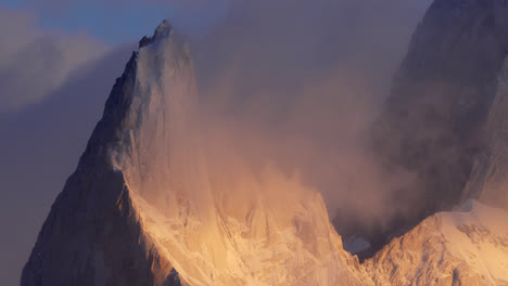 poincenot summit near fitz roy covered by ethereal clouds and bathed in golden light. static view, pan left to right