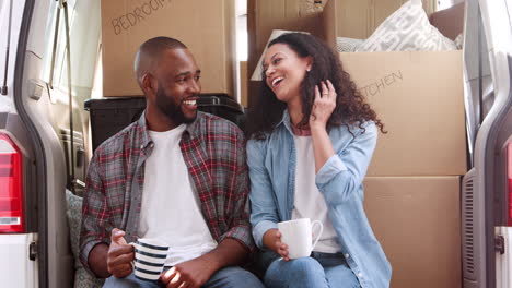 Couple-Taking-A-Break-In-Back-Of-Removal-Truck-On-Moving-Day