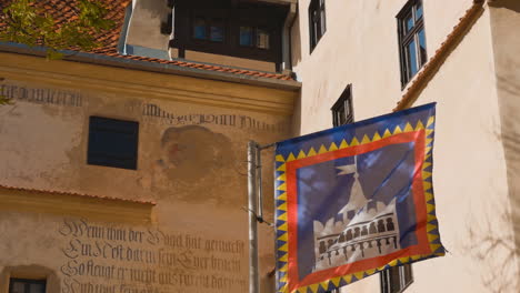 flapping flag with picture of castle outdoors. exterior of the bran castle on autumn weather.
