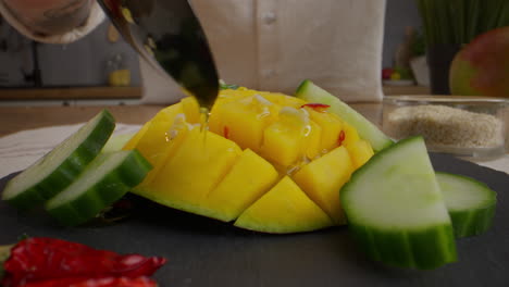 preparing a mango and cucumber salad