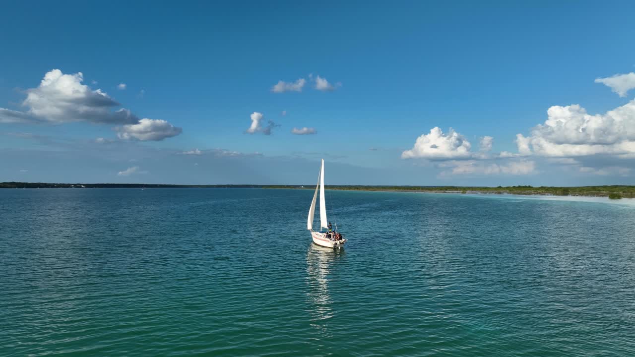 vista aérea orbitando alrededor de un velero en el lago bacalar, en soleado, méxico