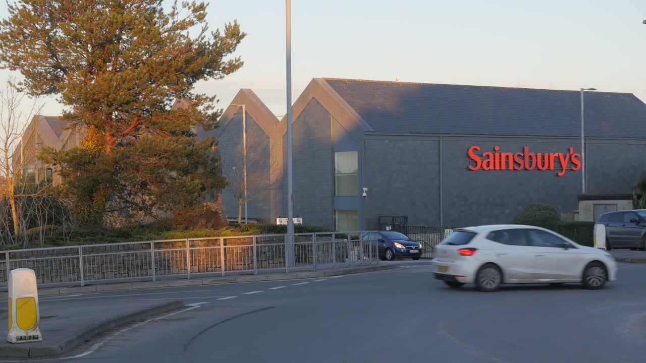 Busy traffic on roundabout outside Sainsburys Supermarket in Truro, Cornwall.