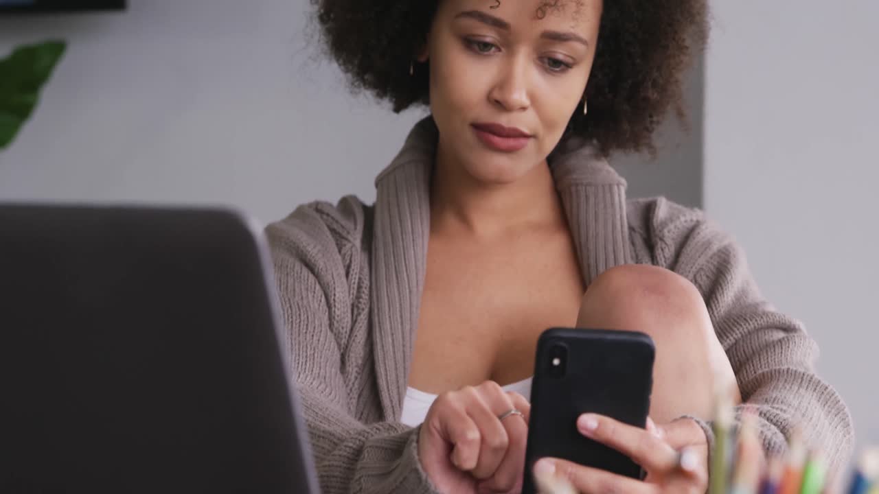 Woman working on laptop and using mobile phone
