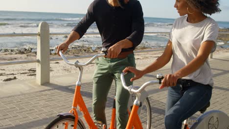 pareja con bicicleta en la playa 4k