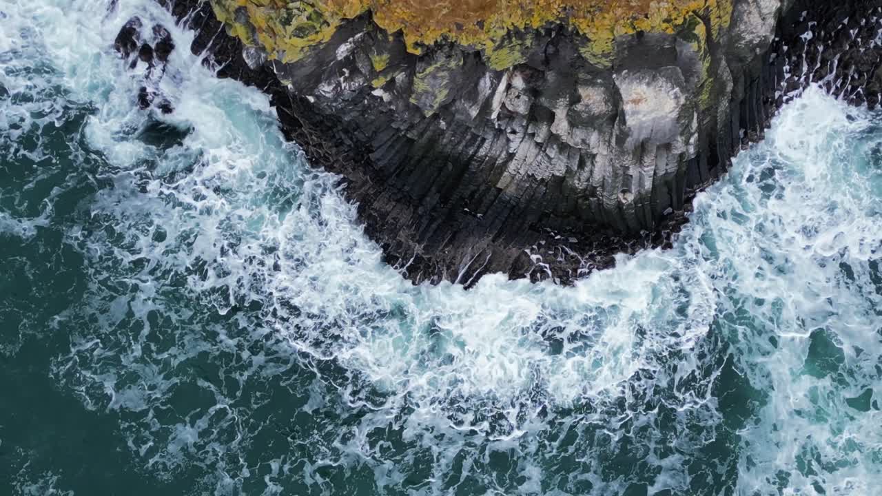 Costa rocciosa vulcanica, onde che si infrangono sulla scogliera, vista aerea dall'alto