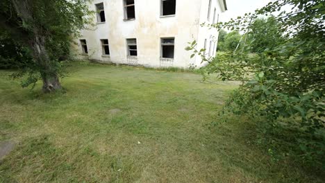 Smooth-slowmotion-tilt-of-white-abandoned-house-with-broken-windows