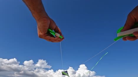 increíble punto de vista de manos adultas volando cometa verde sosteniendo carretes de hilo verde