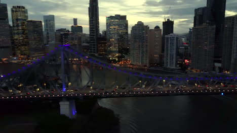 aerial pan shot of story bridge by night on brisbane river, queensland
