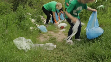 Volunteer-team-cleaning-up-dirty-park-from-plastic-bags,-bottles.-Reduce-trash-cellophane-pollution