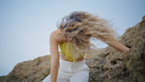 flexible girl artist moving gracefully on stones expressing emotions close up.