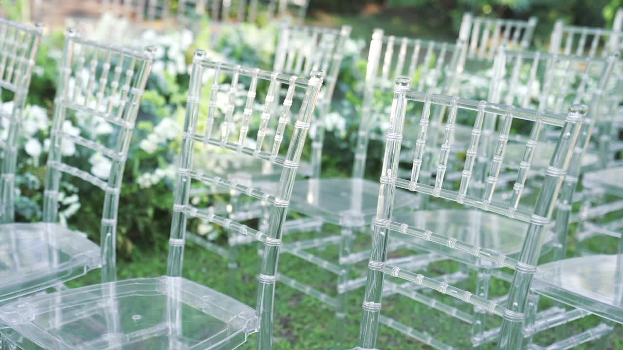 Elegant outdoor wedding setup with ghost chairs and white flowers, luxury event design
