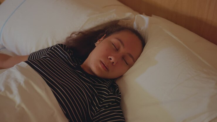 Donna irrequieta che fatica a riposare. Una donna a letto si muove costantemente ed è sveglia. Una donna giace irrequieta nel letto dell'hotel, incapace di trovare pace. Una donna a letto continua a muoversi e non riesce a dormire serenamente stanotte.