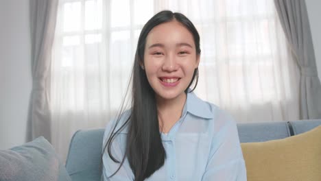 asian woman talking to camera in home living room, video in 4k
