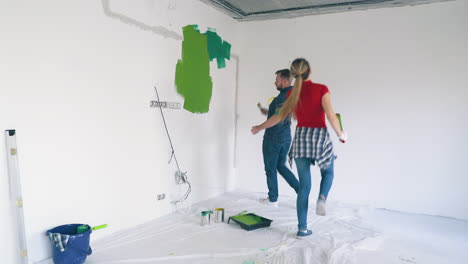 couple has fun painting white wall in renewing room