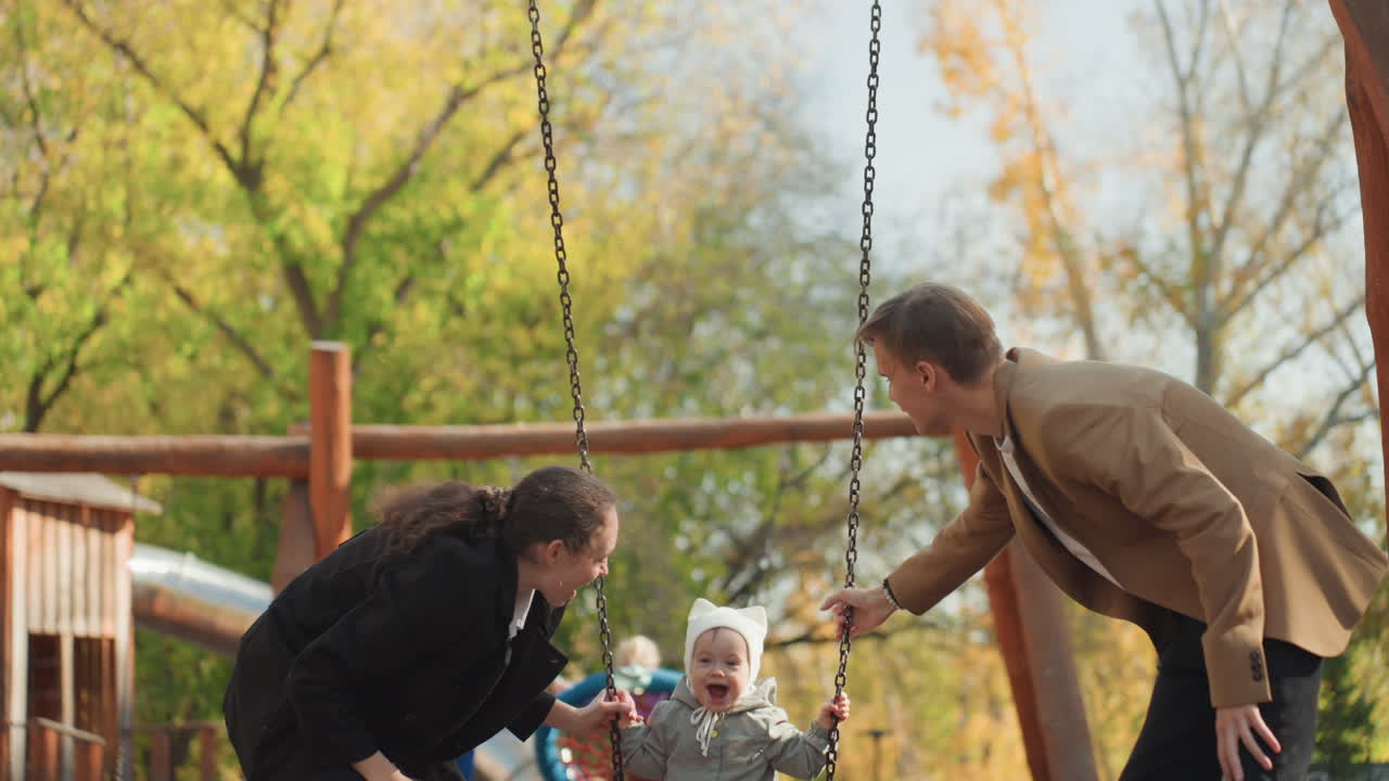 Madre e padre ridono spingendo il bambino sull'altalena, scena al parco che mostra il legame familiare coniugale, interazione genitoriale giocosa e supporto reciproco, momento emotivo spontaneo con luce solare e sfondo verde.
