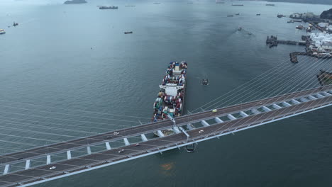 traffic on a supsension bridge with a large container vessel approaching