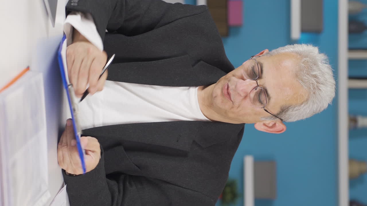 video vertical de un trabajador de la oficina en casa en un estado de ánimo alegre.