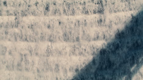 white water rushing down new croton dam stepped spillway with hard shadow from bridge used as composition element. static shot, slow motion 40 fps