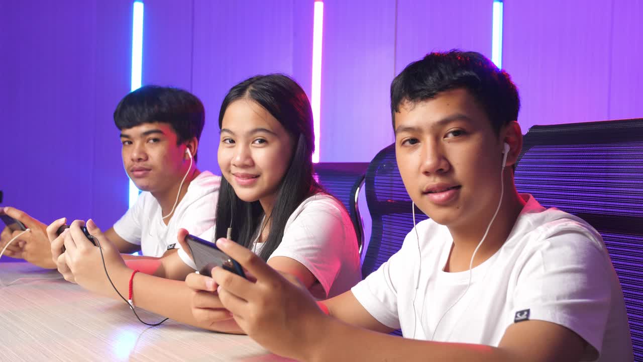 Team Of Asian Esport Gamers Playing In Competitive Video Games On A Cyber Games Tournament By Mobile Phone And Posing