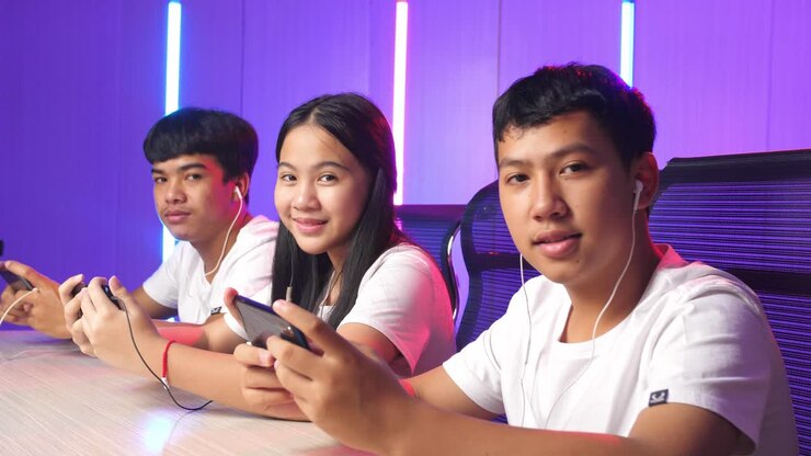 Team Of Asian Esport Gamers Playing In Competitive Video Games On A Cyber Games Tournament By Mobile Phone And Posing