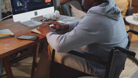 hombre en silla de ruedas trabajando en una computadora