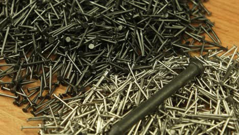 big metal straight pin is on a pile of small nails variety of forms