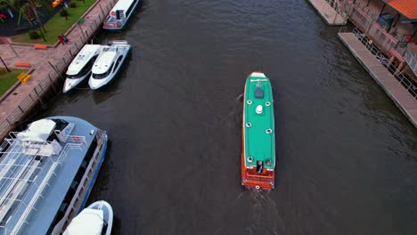 Vista-Aérea-De-Un-Yate-Y-Un-Remero-Moviéndose-En-El-Río-Tigre-En-La-Provincia-De-Buenos-Aires,-Argentina