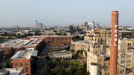 san antonio pearl district aerial view pan left past brick tower, shops and restaurants with drone in 4k