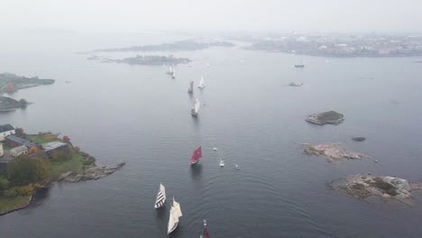 aerial footage of tradtional wooden sailing ships sailing in front of port of helsinki finland