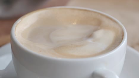 croissant dipping in cappuccino
