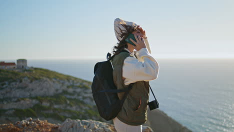 happy tourist speaking smartphone at ocean sunset. joyful girl enjoy landscape