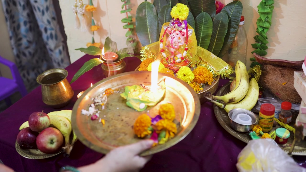 Adorazione dell'idolo del Signore Ganesha con la sacra aarti in un tempio domestico all'interno.