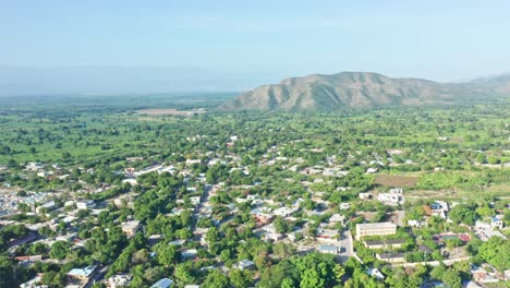 Vista-Aérea-Sobre-El-Suburbio-De-La-Ciudad-Caribeña-De-Neiba-Situada-En-Una-Exuberante-Zona-Natural-De-Montañas-De-Hermosa-Vegetación,-República-Dominicana