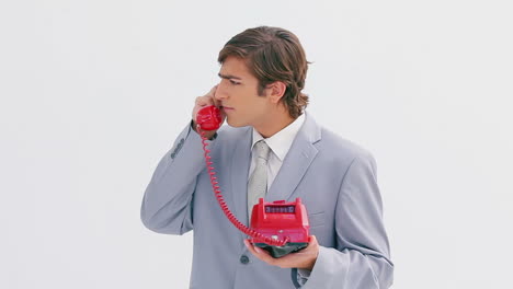un hombre serio contestando el teléfono.