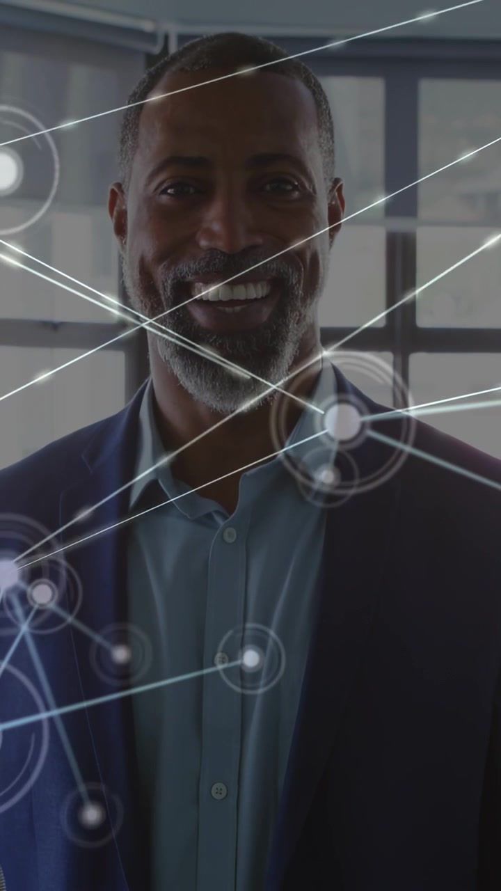 Video verticale: Un dirigente d'azienda in piedi vicino a una finestra, con un'interfaccia HUD che appare sul petto, gestisce nodi tecnologici sorridendo.