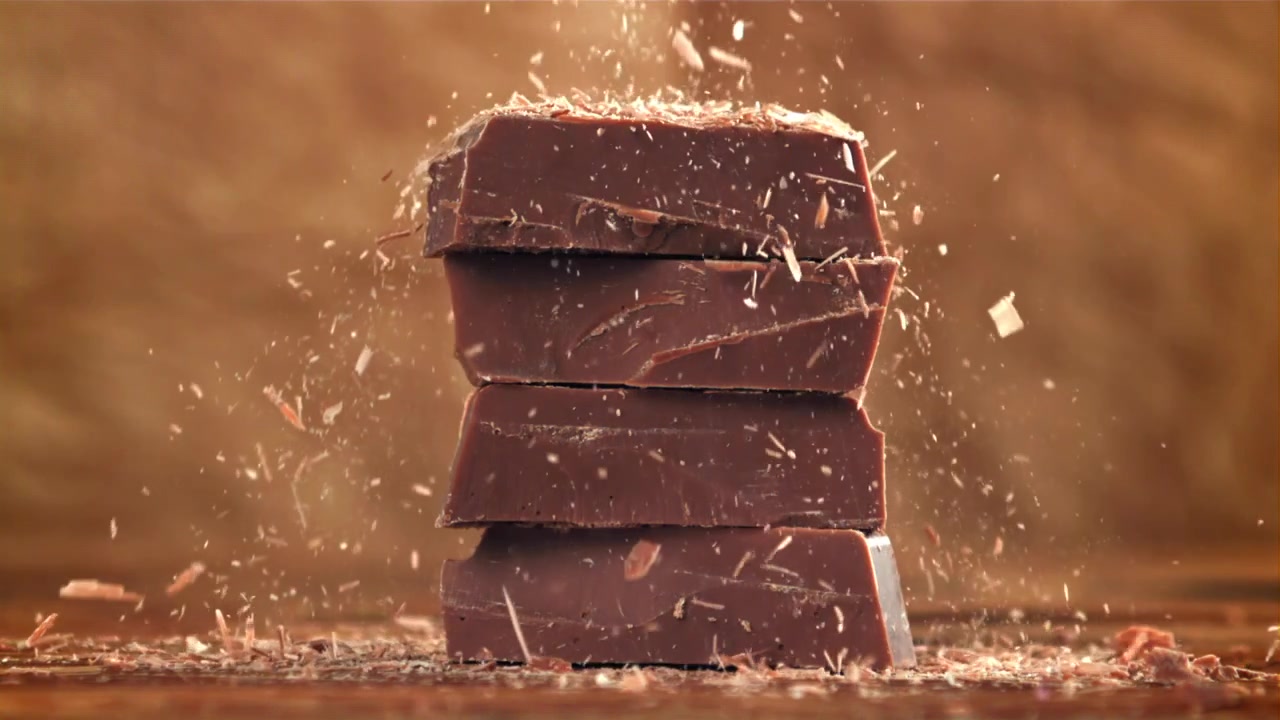 Deliciosas Raspas de Chocolate Caindo sobre Pedaços de Chocolate Empilhados