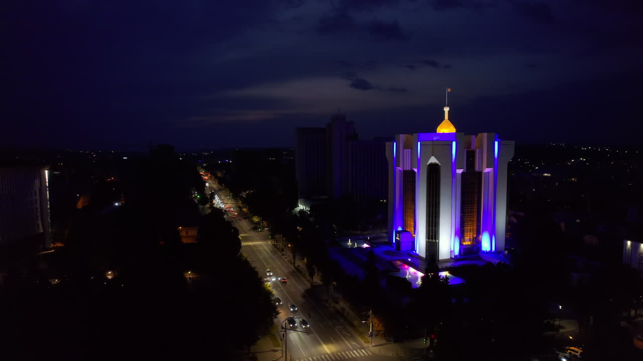 Vista aerea notturna del centro di Chișinău con un drone. Vista del Parlamento, della Presidenza, delle strade con alberi rigogliosi e illuminazione. Moldova