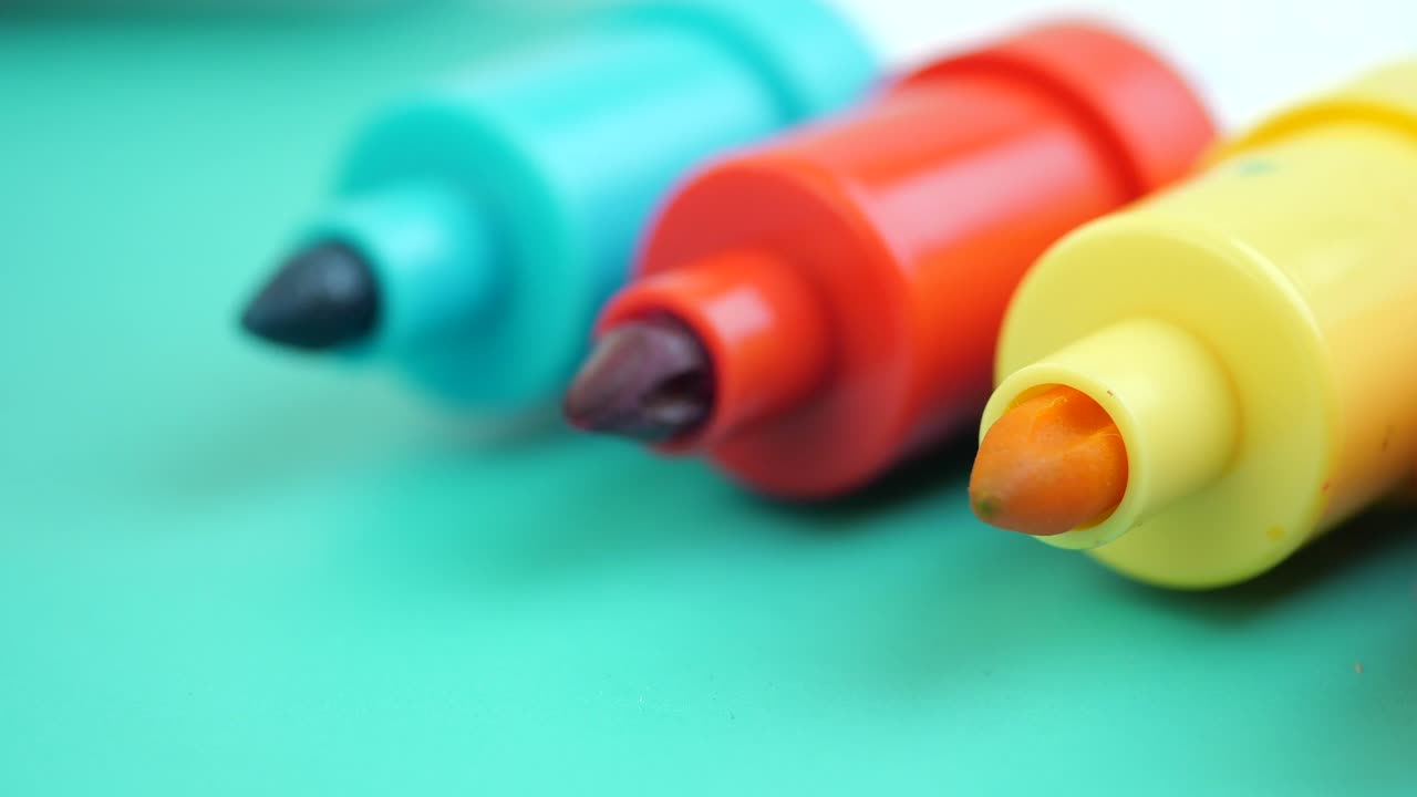 Close-Up of Colorful Markers on a Green Surface